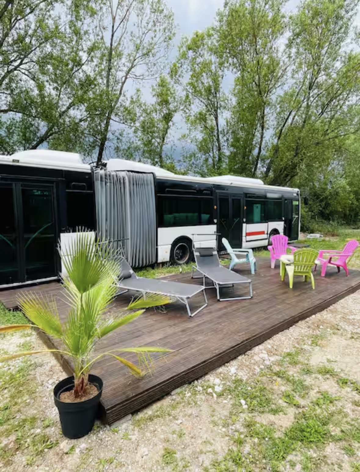 Terrasse extérieure du Bus Insolite avec coin repas et verdure